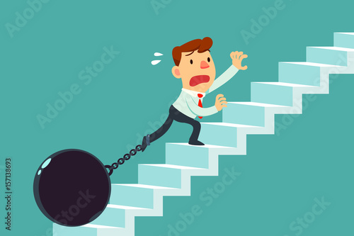 businessman chained to metal ball climbing stair