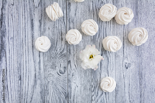 White zephyr and white flower on grey wooden background