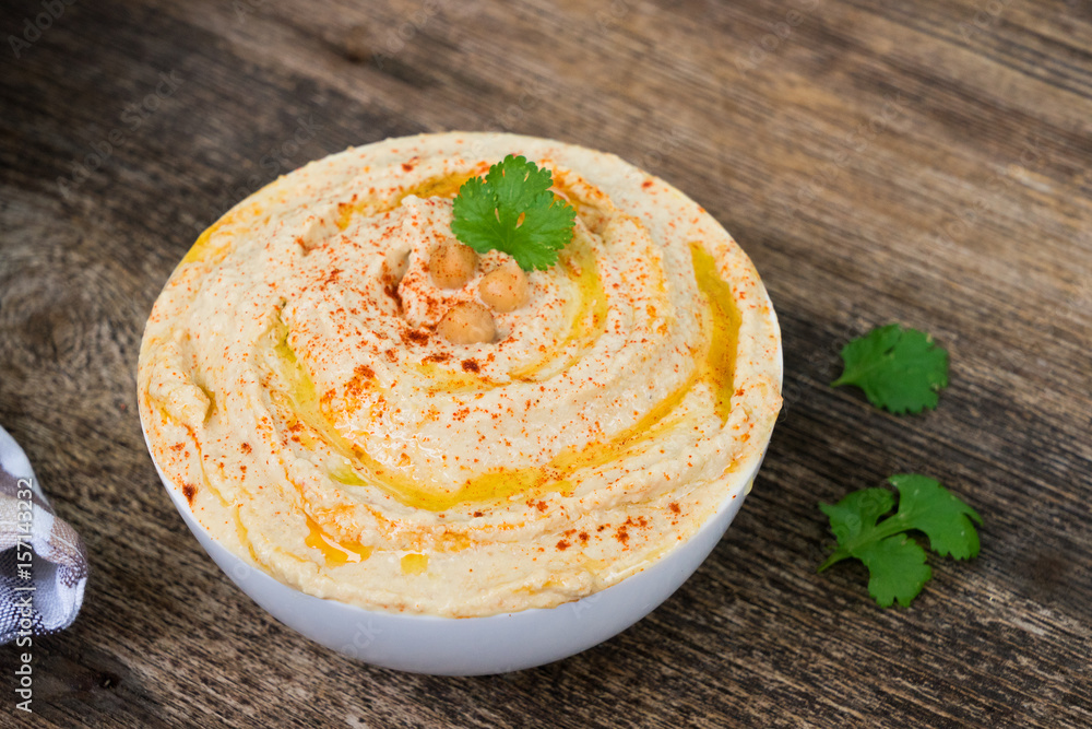 Plate of hummus close up on wooden table Plate of hummus close up on wooden table