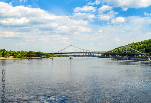Pedestrian bridge over the Dnieper river. Beautiful view on Trukhaniv bridge and cityscape of Kiev, Ukraine.