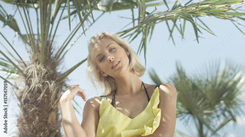 Young beautiful caucasian girl posing over tropical palm trees. Young beautiful caucasian girl posing over tropical palm trees.