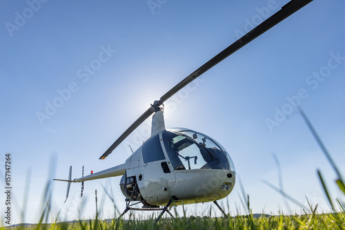 Photo sur Plexiglas Petit hélicoptère utilitaire léger Robinson R22  stationné sur l&#39;aéroport d&#39;herbe. L&#39;un des hélicoptères légers  les plus populaires au monde avec des pales jumelées et un seul moteur -  Nikkel-Art.fr