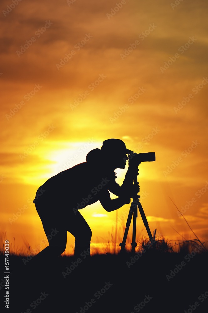 Silhouette of female photographer during sunset
