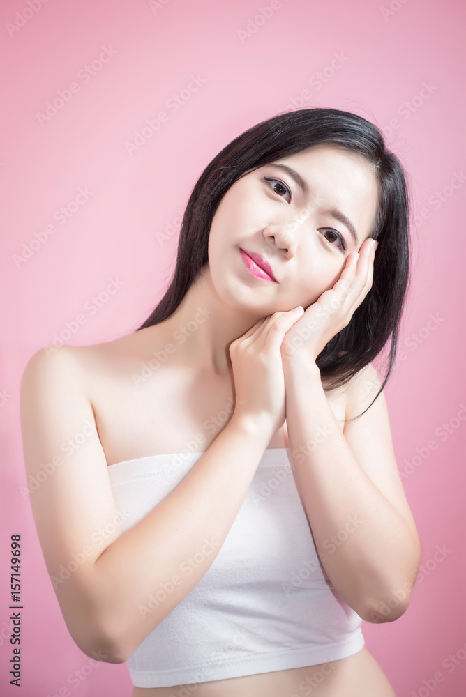 Long hair asian young beautiful woman cross arm and point finger upward isolated over pink background. natural makeup, SPA therapy, skincare, cosmetology and plastic surgery concept. Long hair asian young beautiful woman cross arm and point finger upward isolated over pink background. natural makeup, SPA therapy, skincare, cosmetology and plastic surgery concept.