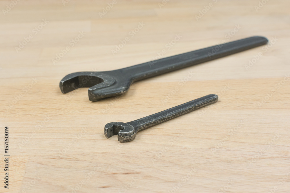 Two old spanners on a wooden table Two old spanners on a wooden table