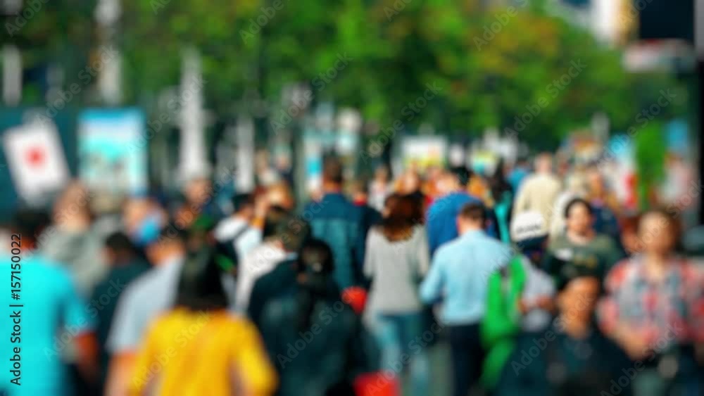 Crowd of People / Commuters Walking / Busy Street. Anonymous crowd on a busy street. People walk down a busy street with green trees on a hot summer day. Slow motion. Crowd of People / Commuters Walking / Busy Street. Anonymous crowd on a busy street. People walk down a busy street with green trees on a hot summer day. Slow motion.