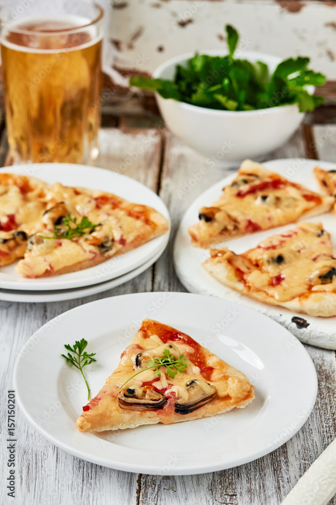 Italian Seafood pizza slice with mussels,tomatoes on a white plate. vertical Italian Seafood pizza slice with mussels,tomatoes on a white plate. vertical