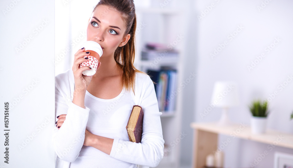 Attractive young businesswoman standing near wall in office Attractive young businesswoman standing near wall in office