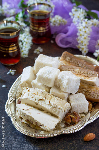 Rahat Lukum, sherbet, halva and tea on the kitchen table. Turkish and Arabic sweets. Ramadan food.