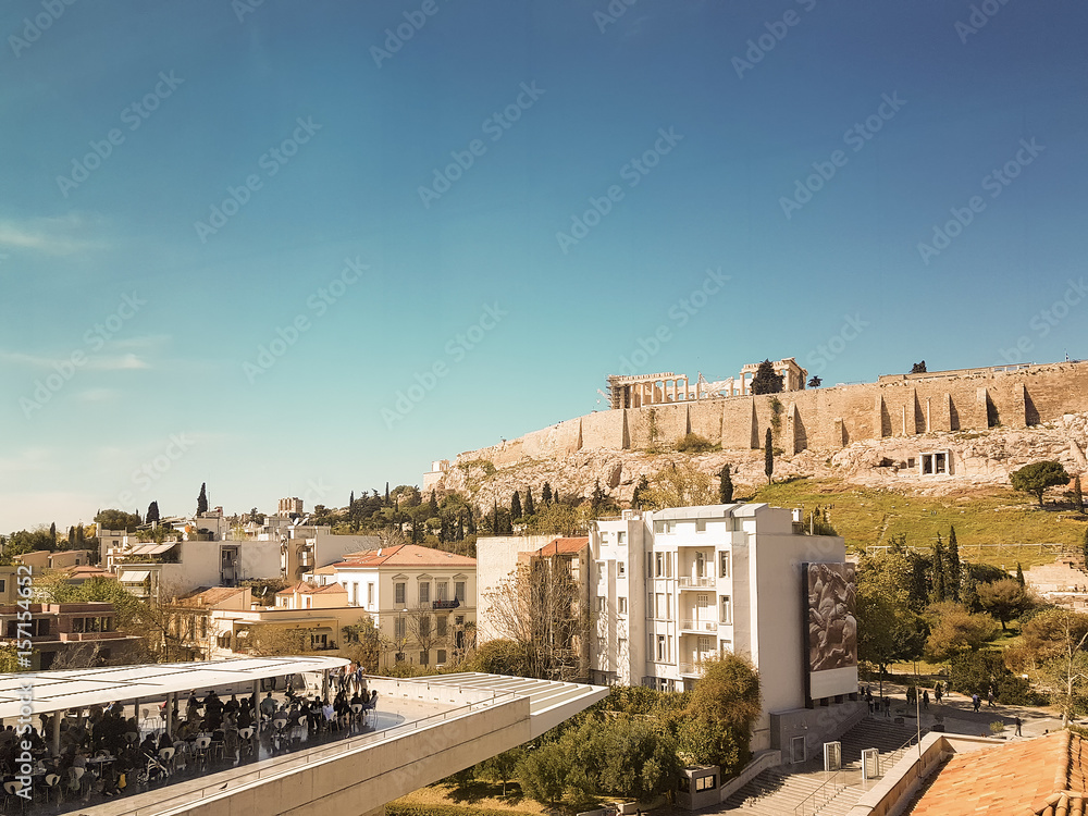 Beautiful view of Acropolis of Athens with people enjoying their coffee.