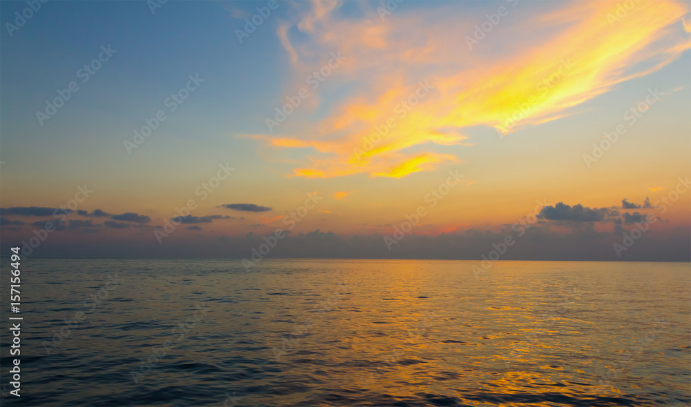 Obraz premium Colorful bright sunset sunrise colors the cloud in orange over the sea surface