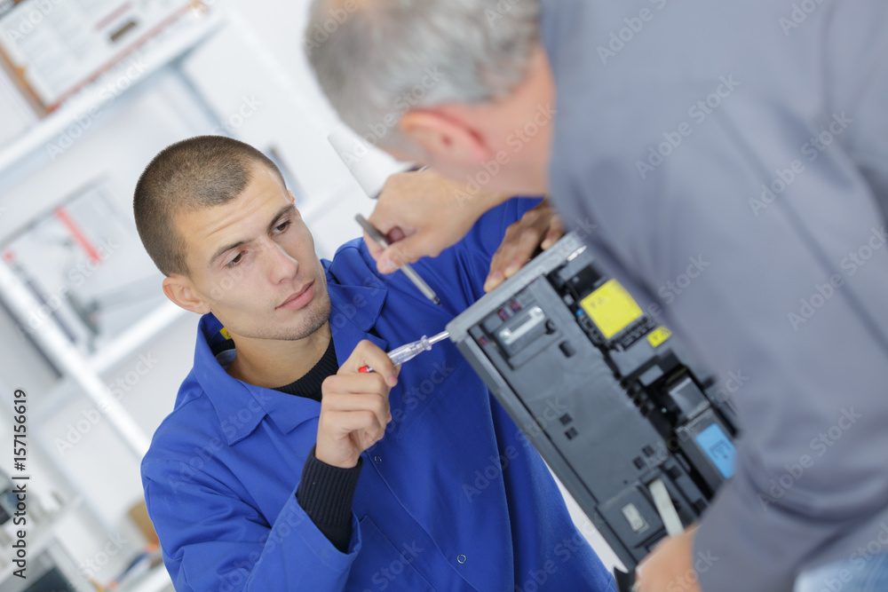 Apprentice working on electrical appliance