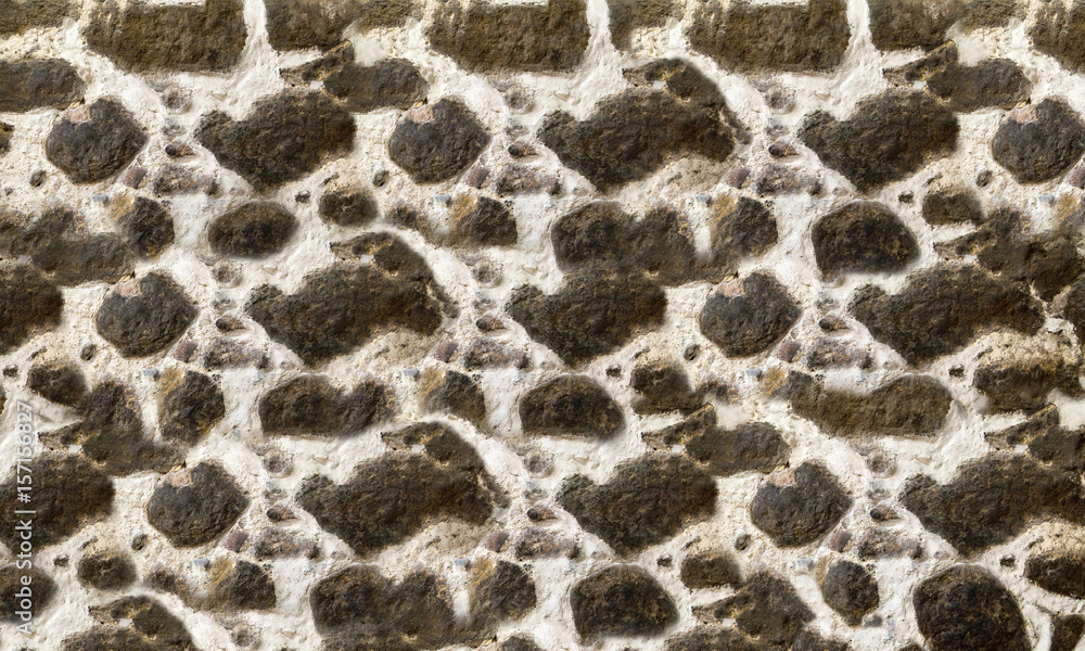 Textured stone walls built of large rough stones held together by dark lumps of white cement limestone