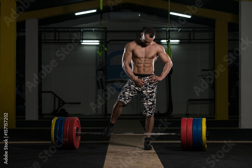 Bodybuilder Performing Back Exercising With Barbell In Gym