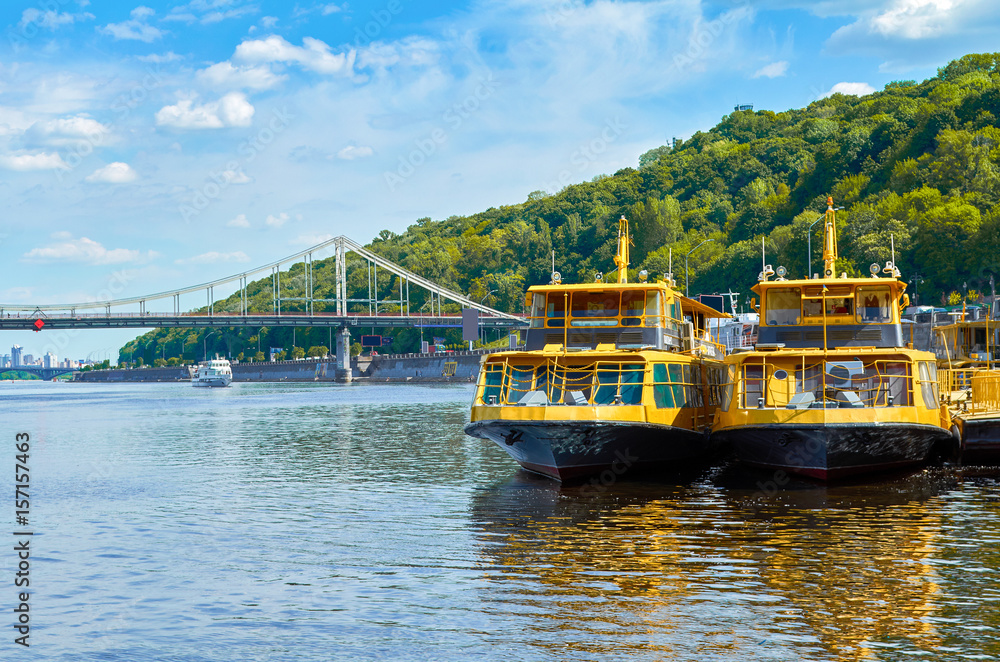 Fototapeta premium Tourist boats on the river quay in Kiev on a tour of the Dnieper, Kiev, Ukraine.