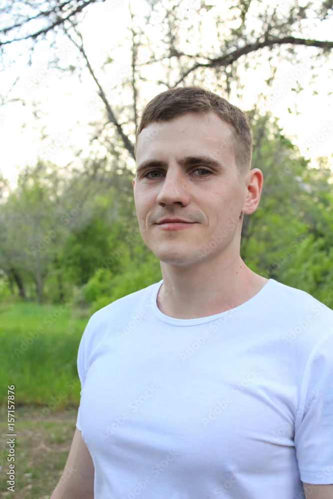 молодой человек в белой футболке на природе молодой человек в белой футболке на природе