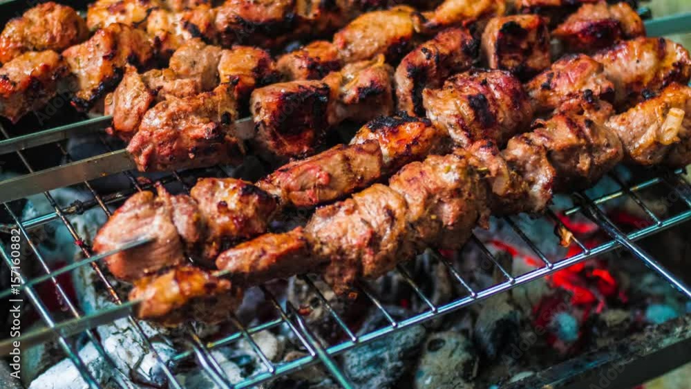 Meat grilled on skewers over the glowing. Tasty food for barbecue party. Roasted grill meat with crust. Close up of pork meat prepared on fire glow. Cooked shashlik or shish kebab Meat grilled on skewers over the glowing. Tasty food for barbecue party. Roasted grill meat with crust. Close up of pork meat prepared on fire glow. Cooked shashlik or shish kebab