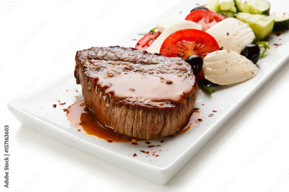 Grilled steak with mozarella and vegetables on white background Grilled steak with mozarella and vegetables on white background