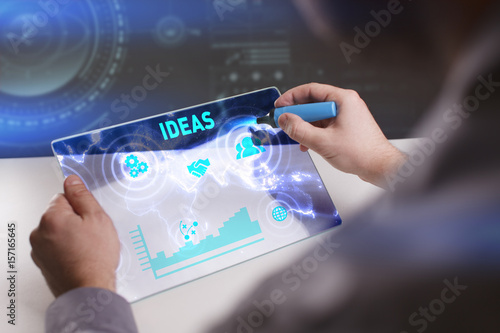 Business, Technology, Internet and network concept. Young businessman working on a virtual screen of the future and sees the inscription: Ideas