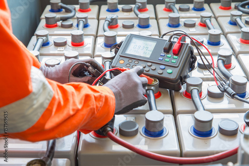 Fotografia Electrician specialist inspect, check voltage and internal resistance of batteries by using battery to preventive maintenance, offshore oil and gas occupational