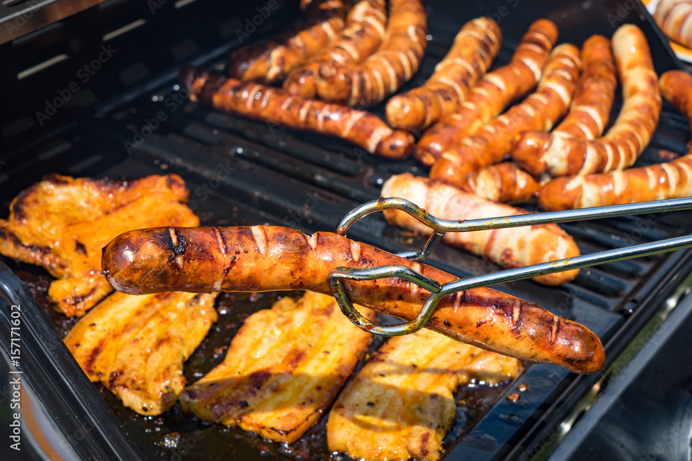 Foto De Grillsaison Grillzange Mit Fertig Gebratener Grillwurst ber foto-de-grillsaison-grillzange-mit-fertig-gebratener-grillwurst-ber