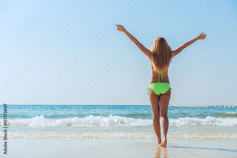 Sexy bikini body asian woman playful on paradise tropical beach having fun playing splashing water in freedom with open arms. Beautiful fit body girl on travel vacation. Banner crop for copy space. Sexy bikini body asian woman playful on paradise tropical beach having fun playing splashing water in freedom with open arms. Beautiful fit body girl on travel vacation. Banner crop for copy space.