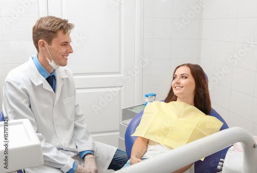 Male dentist and young female patient in clinic