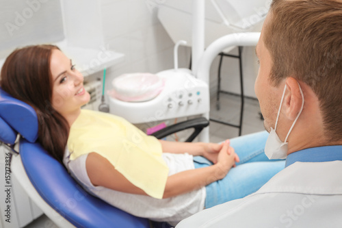 Male dentist and young female patient in clinic