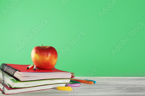 School stationery with apple on green background