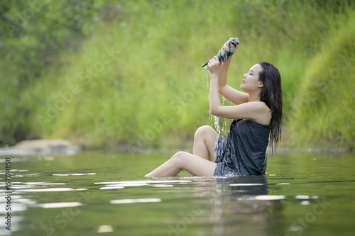 The girl was bathing brook,country girl portrait in outdoors,beautiful happy Asian girl smile and laugh together.