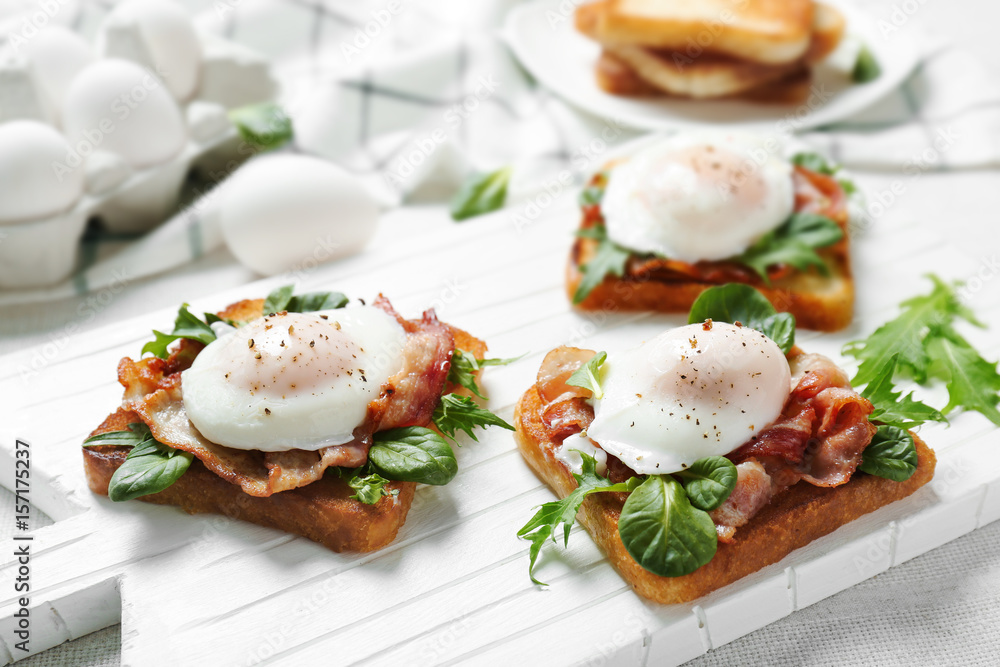 Tasty eggs Benedict on cutting board Tasty eggs Benedict on cutting board