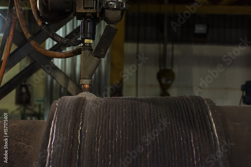 Fotografija Overlay welding hard surfacing of steel roll by submerge arc welding process