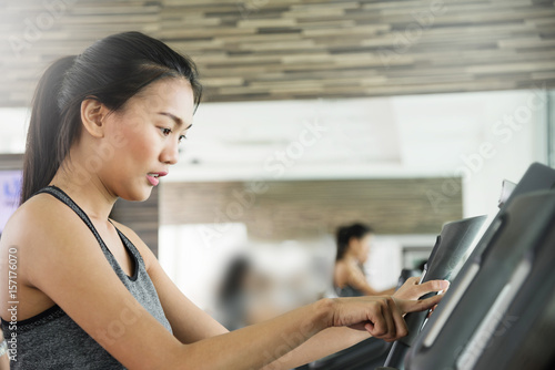 Asian woman in sportswear using treadmill at the gym. Free Download Asian woman in sportswear using treadmill at the gym. - GFXLoad
