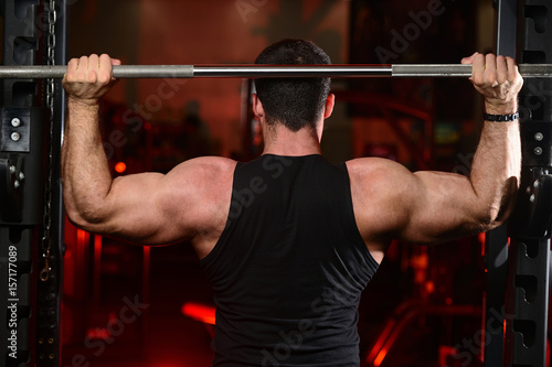 Brutal strong athletic men pumping up muscles train in gym