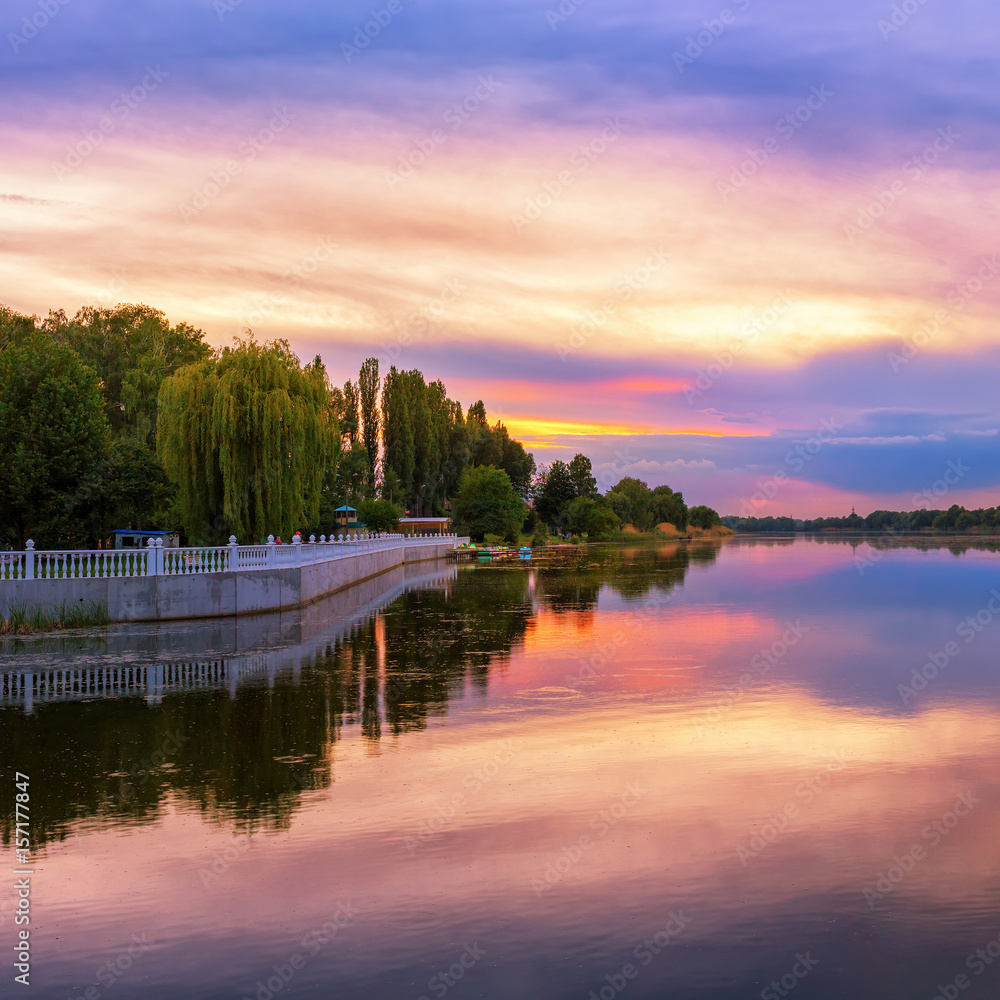 Obraz premium Vivid scenery of sunset at the river, colorful, dramatic evening sky reflected in the water, hdr image. Khmelnytskyi, Ukraine