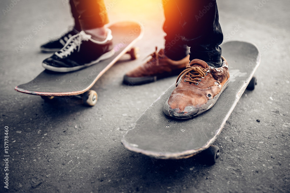 Group of friends skateboarders rest on the street and skateboard, shoes in  holes and scuffs. Concept street hooligans. Monochrome and high contrast.  Photos | Adobe Stock