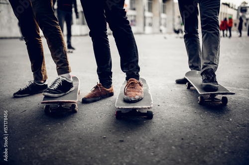 Group of friends skateboarders rest on the street and skateboard. Concept active rest with friends outdoors in summer. Monochrome and high contrast.