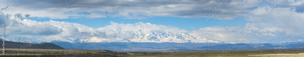 panoramic view of plain at root of mountains with cloudy sky on background panoramic view of plain at root of mountains with cloudy sky on background