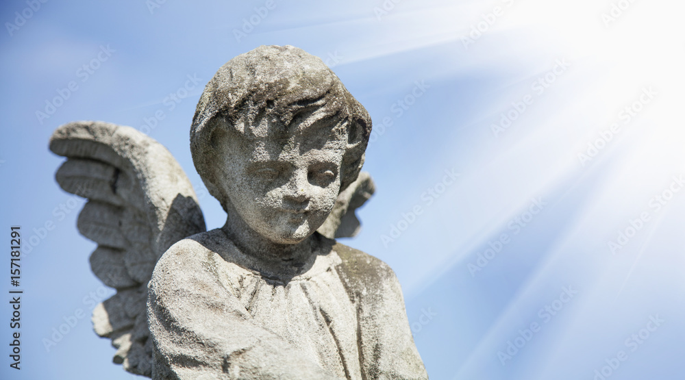 Guardian angel statue in sunlight as a symbol of strength, truth and faith.