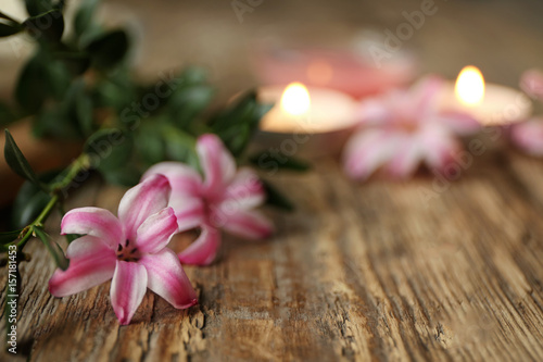 Beautiful spa composition with flowers and candles on wooden background