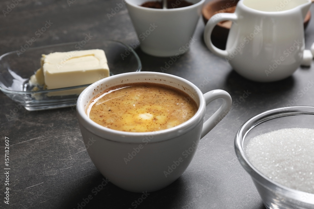 Cup of coffee with butter on table