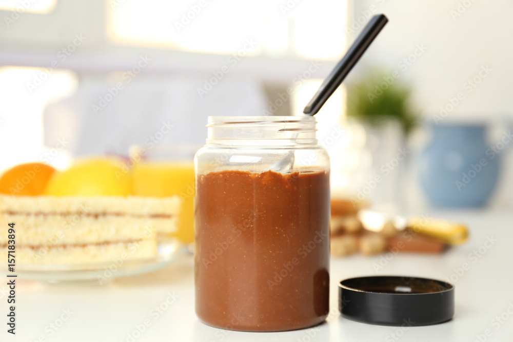 Delicious peanut butter in jar on kitchen table Delicious peanut butter in jar on kitchen table