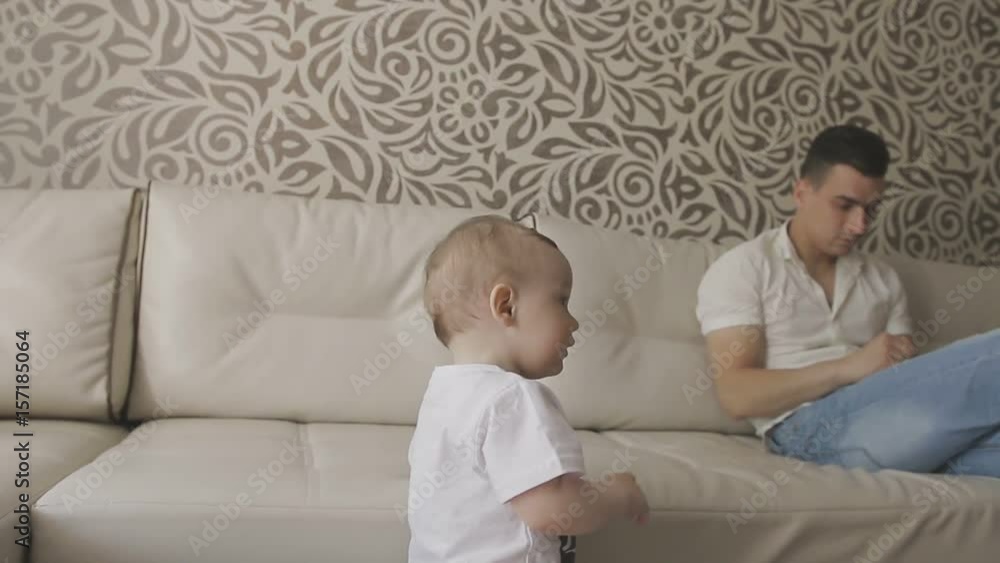 A little child drinks milk from a bottle. Family at home A little child drinks milk from a bottle. Family at home
