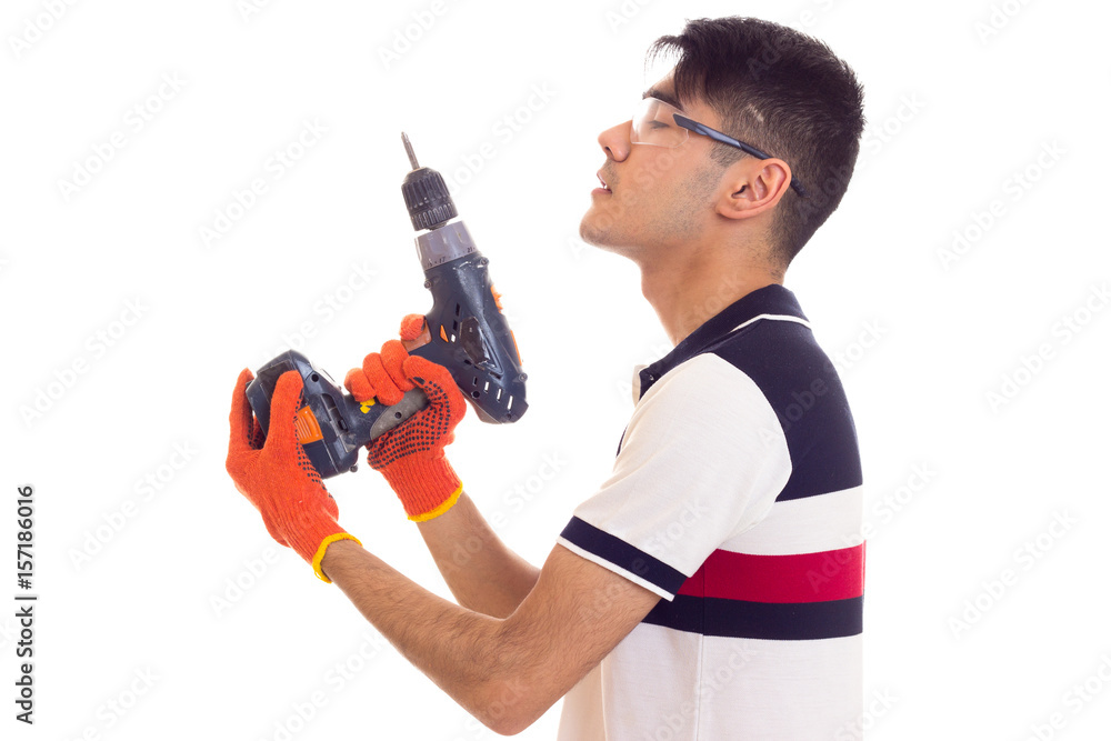 Young man with gloves and glasses holding electric screwdriver Young man with gloves and glasses holding electric screwdriver