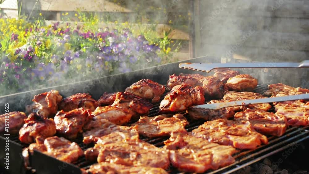 barbecueing on beautifull sunny day. turning steaks, chicken legs close-up slowmotion hd barbecueing on beautifull sunny day. turning steaks, chicken legs close-up slowmotion hd