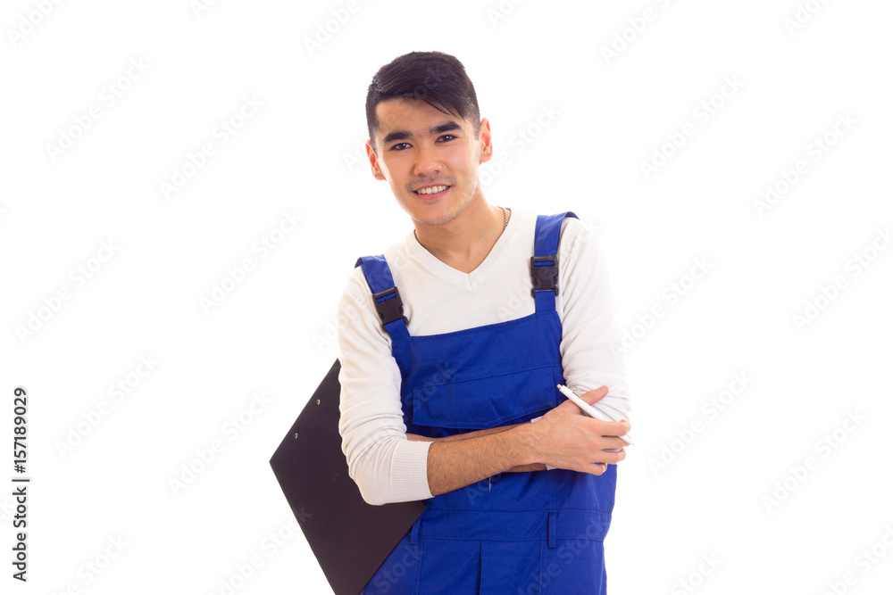 Young man in blue overall holding pen and folder Young man in blue overall holding pen and folder