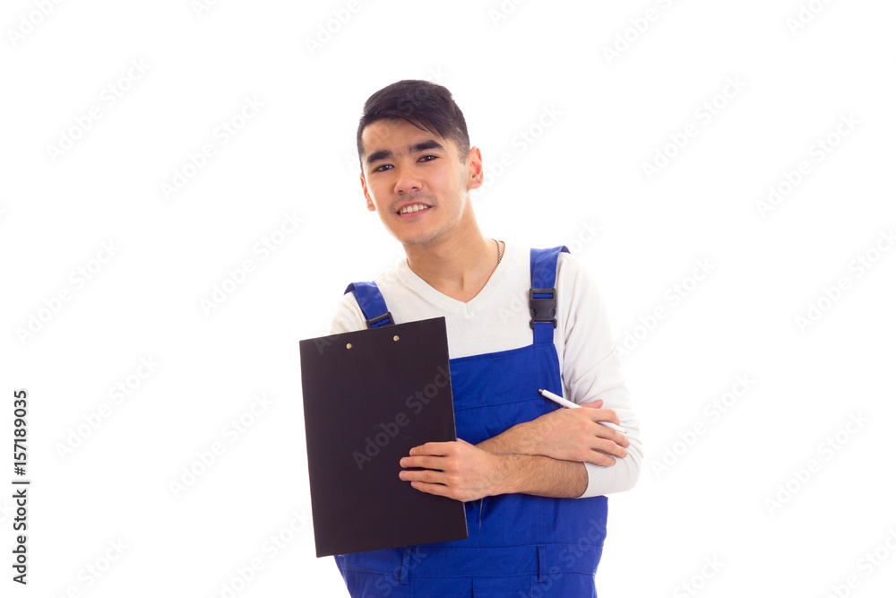 Young man in blue overall holding pen and folder