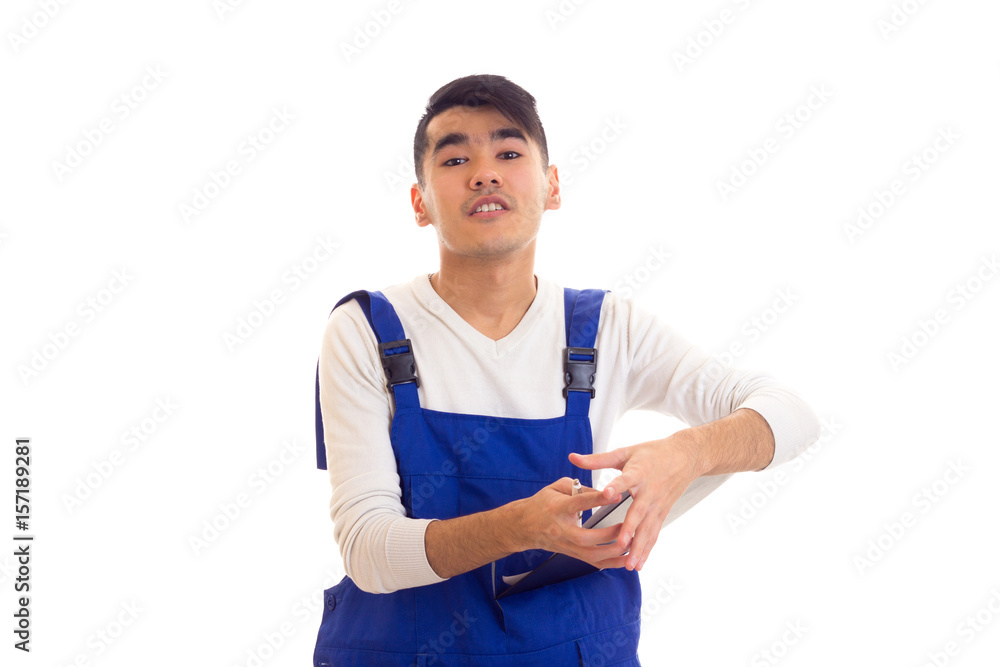 Young man in blue overall holding pen and folder Young man in blue overall holding pen and folder