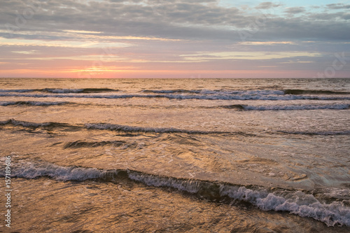 Sunset on Baltic Sea white pastel color sky and rough sea.