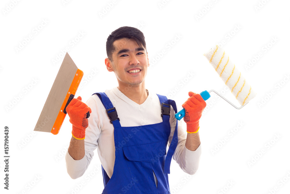 Man in blue overall with gloves holding spatula and roll Man in blue overall with gloves holding spatula and roll